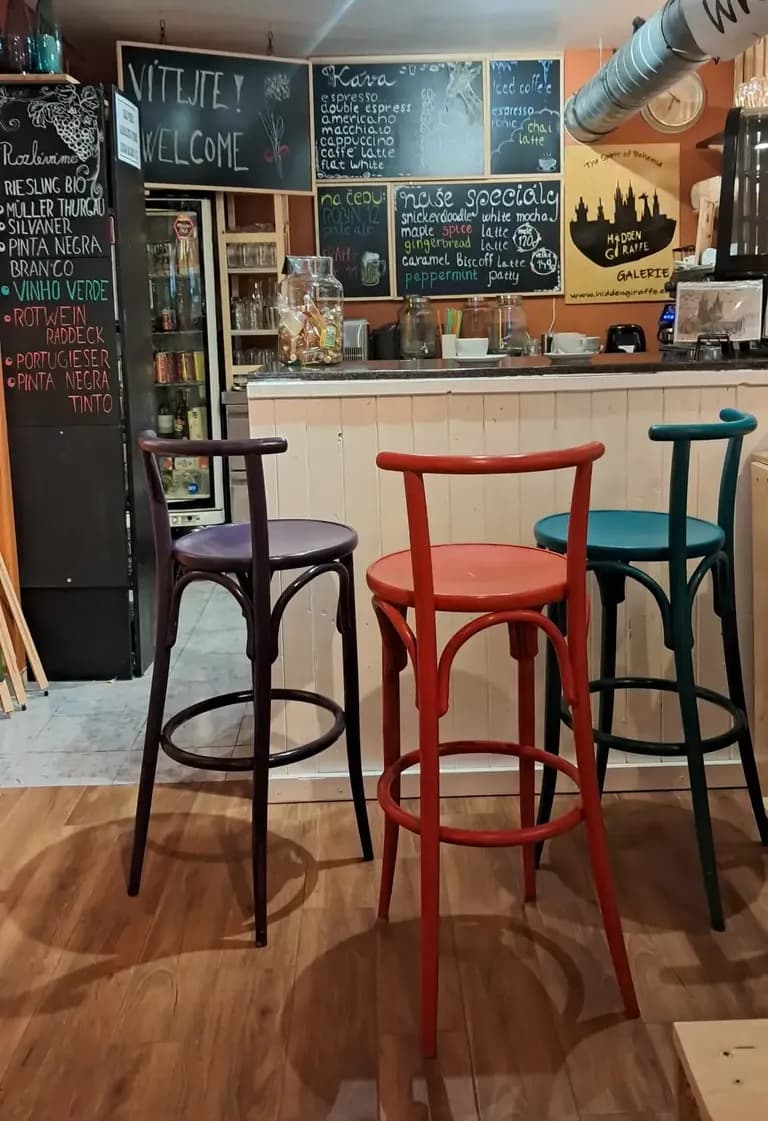 Interior of Hidden Giraffe Gallery Café with colourful bar chairs, chalkboard menus and a cosy atmosphere.