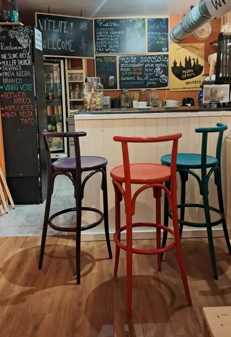 Interior of Hidden Giraffe Gallery Café with colourful bar chairs, chalkboard menus and a cosy atmosphere.